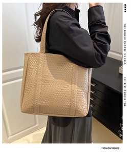 Detail of khaki woven tote bag showing large capacity and elegant shoulder strap fit