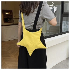 Close-up of bright yellow star-shaped canvas crossbody bag with black wide shoulder straps