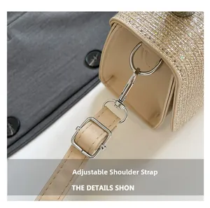 Detail of adjustable leather strap with silver metal buckle on a glittery beige handbag