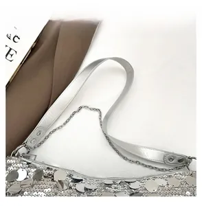 Detail view of silver sequin crescent bag with adjustable wide strap and metal chain