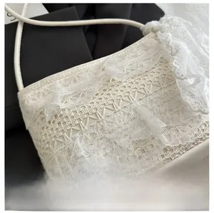 Gros plan sur un sac à bandoulière en dentelle blanche avec broderies florales chic