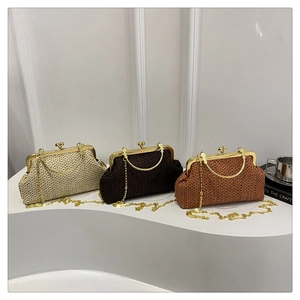 Close-up of three woven straw shell bags in cream, brown and tan with gold chain straps