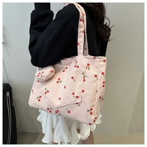 Détail du sac cabas en velours côtelé rose à motifs cerises avec petite pochette