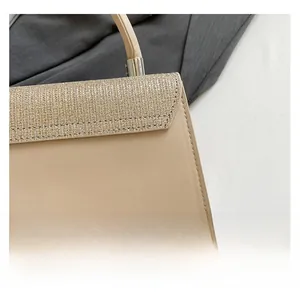 Macro detail of beige handbag featuring gold sequin texture and smooth faux leather