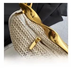 Detail view of the gold-tone smooth zipper and textured woven fabric on the handbag