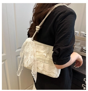 Détail d'un sac à bandoulière en dentelle avec tissage ajouré et nœud latéral élégant