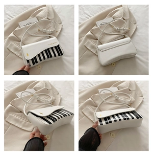 Detail view of piano key design on a white crossbody bag with golden music notes