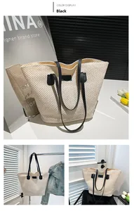 Detail of woven tote bag showing white straw texture and contrasting black handle