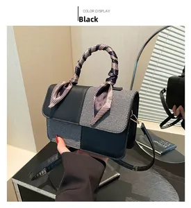 Detail of a chic black contrast handbag with silk scarf handle and detachable shoulder strap