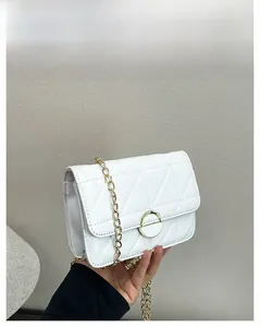 Detailed shot of white quilted leather crossbody bag with gold chain and magnetic closure