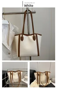 Detail view of large white PU tote bag with brown straps and spacious interior for commute