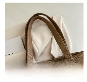 Close-up of the woven brown leather tote bag showing comfortable double handles