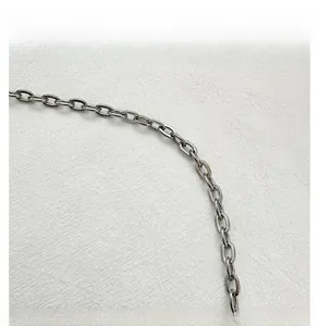 Detailed close-up of the polished silver chain strap on a crescent shoulder bag