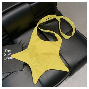 Detail of star-shaped bright yellow crossbody canvas bag on a black leather surface