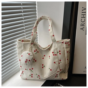 Gros plan du sac cabas en velours beige à motif cerises avec petite pochette ronde