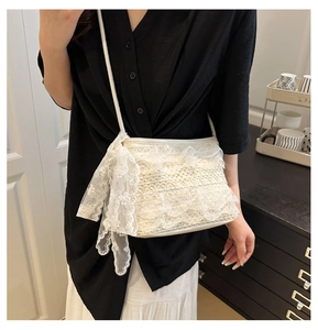 Vue détaillée du sac seau en dentelle blanche crochetée avec nœud élégant en bandoulière
