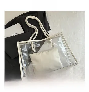 Detail view of large transparent PVC tote bag with white rope handles and inner pouch