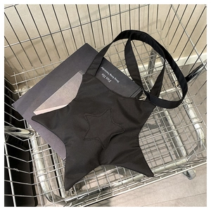 Macro shot of a black star-shaped canvas shoulder bag inside a metal shopping basket