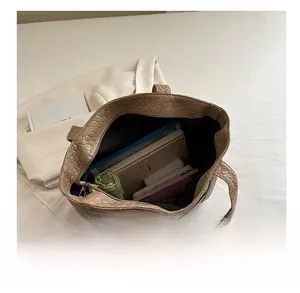 Spacious khaki woven leather tote bag showing large interior capacity for daily essentials
