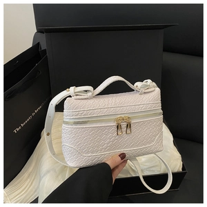 Detail view of white woven texture bag with gold double zippers in a gift box