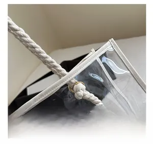 Detail of woven rope handle and gold hardware on transparent PVC tote bag