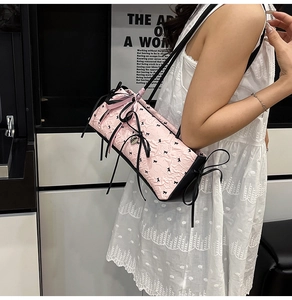 Detail der rosa Seersucker-Tasche mit schwarzen Seidenschleifen und schmalem Gurt