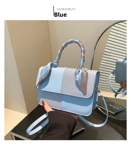 Close-up of light blue handbag featuring woven textures and a brown checkered silk scarf