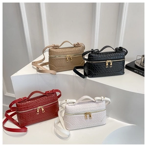 Detailed view of square woven leather bags in four colors with gold zipper hardware