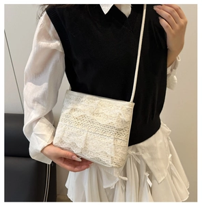 Vue détaillée d'un sac à bandoulière en dentelle blanche avec trois couches de volants fins