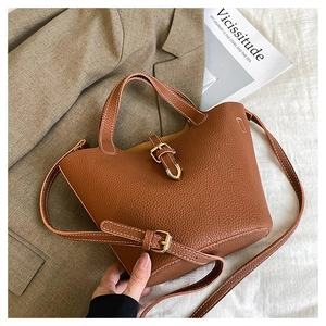 Detailed view of brown lychee texture leather with contrast stitching and golden buckle
