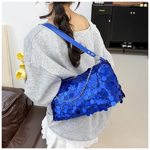 Detail of bright blue sequin shoulder bag with chain strap and shiny reflective texture
