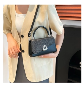 Detail view of black leather mini square bag with silver sequins and heart-shaped lock