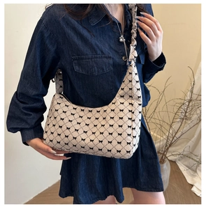 Detail of checkered hobo bag with black bow patterns and ruffled shoulder strap style