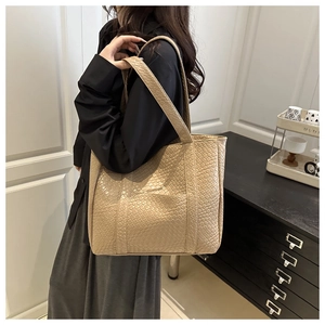 Detail of minimalist woven beige tote bag with a high-gloss finish and large capacity