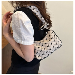 Detail of beige corduroy tote with black bows and ruffled scrunchie handle strap