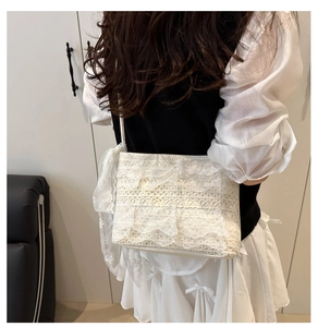 Détail du sac à bandoulière en dentelle blanche avec des volants et motifs floraux