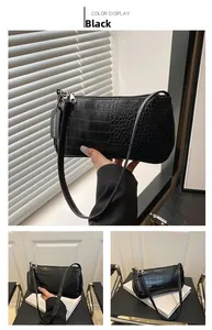 Détail du sac baguette noir à motif crocodile avec fermeture éclair en métal argenté
