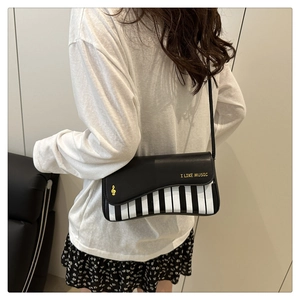 Detail of creative piano-themed crossbody bag with I LIKE MUSIC print on model