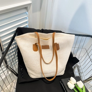 Retro cream woven tote bag with brown leather handles and fashion tag in a cart