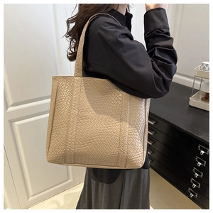 Detail of beige woven texture and front pocket on a large minimalist shoulder tote bag