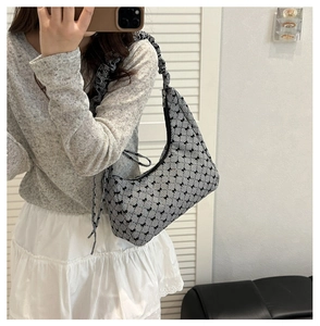 Close-up of hobo bag featuring drawstring strap and trendy bow print patterns