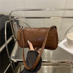 Sac baguette marron rétro avec texture crocodile et détail de l'étiquette mode
