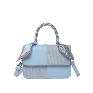 Modern light blue crossbody bag with contrast panel and scarf wrapped handle on white background