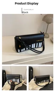 Detail of piano key design underarm bag with I LIKE MUSIC print and golden music note