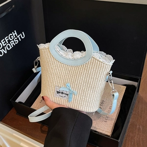 Chic beige straw bucket bag with blue leather handles and delicate lace trim