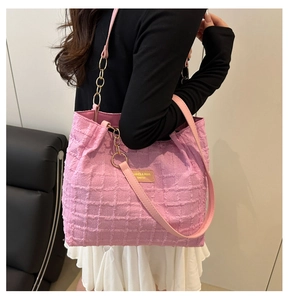 Detail of pink wool tote bag with textured grid fabric and leather branded label