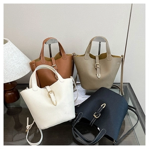 Detailed view of four lychee texture leather bucket bags with metal buckle closures