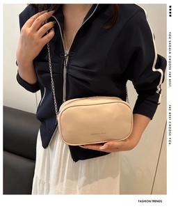 Détail du mini sac blanc crème en cuir avec chaîne argentée et lettrage de mode