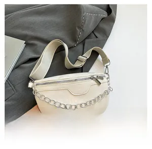 Detail of light beige crescent crossbody bag with pearl chain and fabric shoulder strap