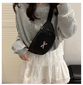 Détail du sac banane en tissu oxford noir avec broderie nœud rose et double fermeture éclair